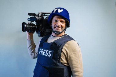 Elinde video kamera tutan kurşun geçirmez yelek giyen bir muhabir.
