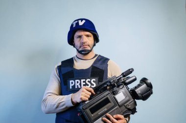 Elinde video kamera tutan kurşun geçirmez yelek giyen bir muhabir.