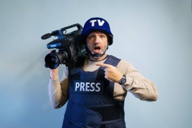 Elinde video kamera tutan kurşun geçirmez yelek giyen bir muhabir.
