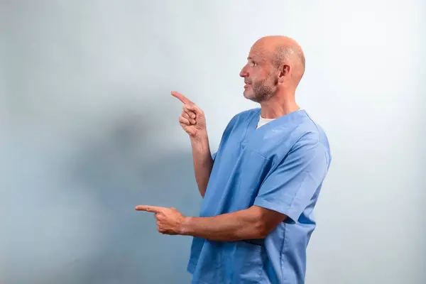 軽い青いガウンを指す理学療法士の肖像画 ロイヤリティフリーのストック写真