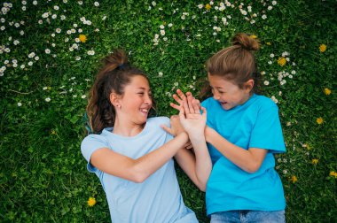 Bahçede oynayan ablası tarafından eşlik edilen bir çocuk..