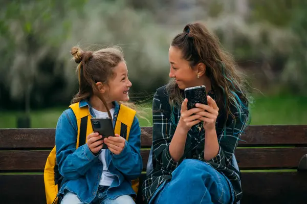 Mały Chłopiec Towarzystwie Starszej Siostry Korzystającej Smartfona Siedzącego Ławce — Zdjęcie stockowe