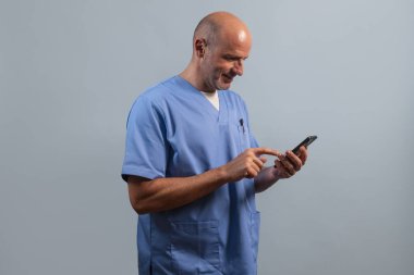 Açık mavi ceket giyen ve akıllı telefon kullanan bir fizyoterapistin portresi..