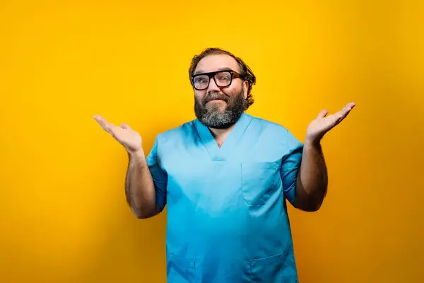 stock image Doctor in blue coat on yellow background gesturing, with surprised expression.