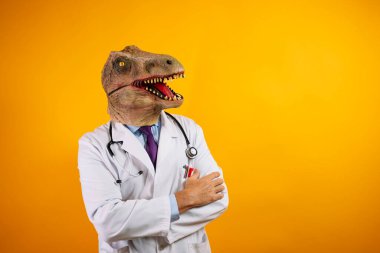 Sarı arka planda dinozor maskeli bir doktor. Jestler yapıyor..