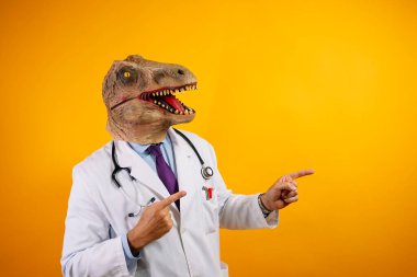 Sarı arka planda dinozor maskeli bir doktor. Jestler yapıyor..