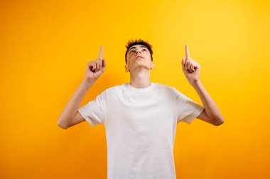 Sarı arkaplanı işaret eden genç.