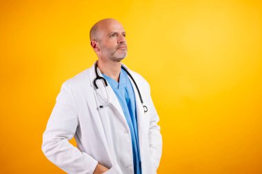 Kendine güvenen bir doktor, beyaz önlük giyiyor ve steteskop tutuyor..