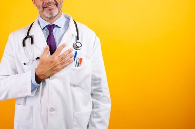 Elleri göğsünde ve acı çekiyor gibi görünen bir doktor..