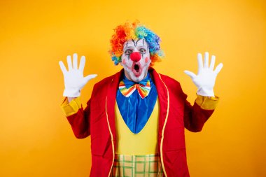 Gökkuşağı peruklu, şaşkın palyaço, gözleri açık, eller yukarı