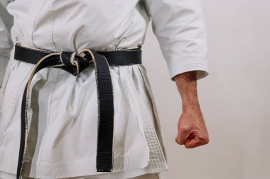 Siyah kuşak beyaz bir kızın etrafına sarılmış..