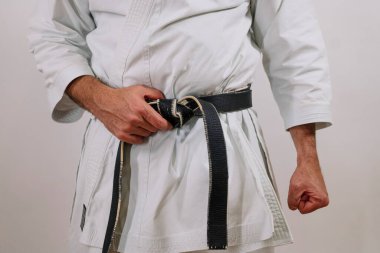 Siyah kuşak beyaz bir kızın etrafına sarılmış..