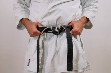 Siyah kuşak beyaz bir kızın etrafına sarılmış..