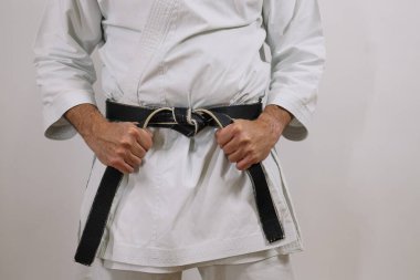 Adam siyah kuşak, dövüş sanatları üniforması giyiyor..