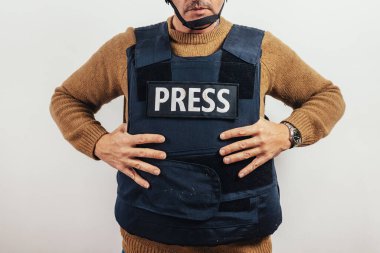 Beyaz arka planda kurşun geçirmez yelek giyen gazeteci.