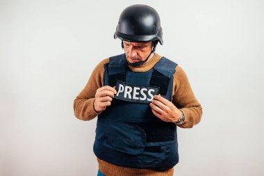 Beyaz arka planda kurşun geçirmez yelek giyen gazeteci.