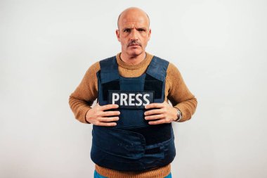Beyaz arka planda kurşun geçirmez yelek giyen gazeteci.