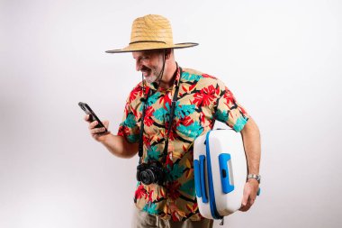 Çantalı gülümseyen adam telefonunu kontrol ediyor..