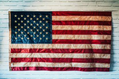 Beyaz tuğla duvarda asılı Amerikan bayrağı