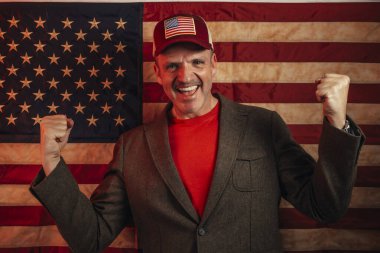 Euphoric American man celebrating with raised fists. clipart