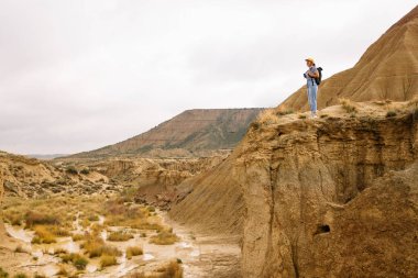 Çölde uçurumun kenarında dikilirken