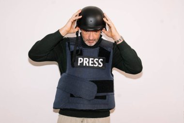 Muhabir kafasına kask takıyor.