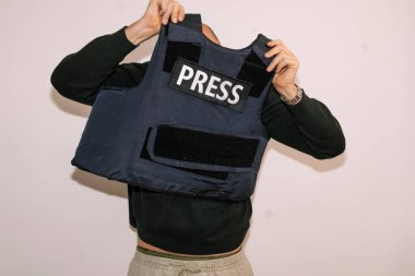 Gazeteci kurşun geçirmez yeleği çıkarıyor