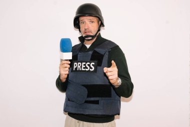 Muhabir mikrofonla el kaldırıyor.