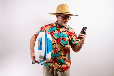 Gezgin telefonu gösteriyor ve mavi bavulu tutuyor.