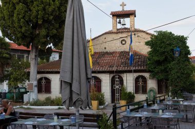 Akşamları Pefkochori, Tebeşir 'de eski bir kasabada bir restoran ve eski bir ortodoks kilisesi manzarası