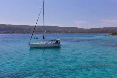 Sithonia Yarımadası 'ndaki Diaporos Adası' nda güzel mavi bir göldeki tekne - Yunanistan