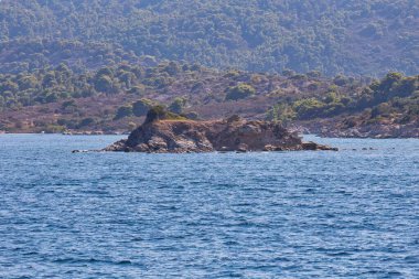 Sithonia yarımadasında kayalar, doğa ve arka planda bulunan deniz suyu - Yunanistan