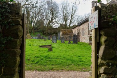 Heysham - Lancashire - Büyük Britanya 'da pencere ve mezarlığı olan eski ahşap bir kapının dikey görüntüsü.
