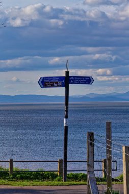 Sahilde deniz kenarındaki bir tabelanın dikey çekimi. Arka planda, güneşli arka planda, Heysham - Lancashire - İngiltere