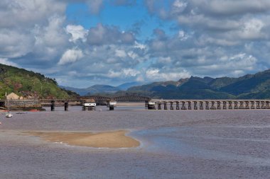 Barmouth, Gwynedd- Wales, Büyük Britanya 'da dağlılarla dolu güzel bir nehir manzarası ve köprüsü.