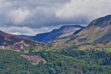 Barmouth, Galler 'deki bulutlu gökyüzü, dağlar ve nehir manzarası.