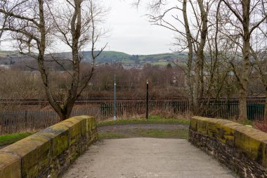 a view of the bridge across the river in a park on a sunny day in Littleborough - Rochdale - Greater Manchester - Lancashire - United Kingdom clipart