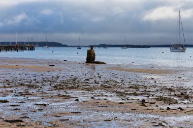 Poole - Dorset - Bournemouth birleşik krallığında bulutlu bir gökyüzü olan sahilde güzel bir tekne görüntüsü.