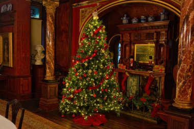 Bir şöminesi ve bir bardak şarabı olan bir Noel ağacının içinde Bournemouth 'daki Russell Cotes Sanat Galerisi ve Müzesi - Dorset - Birleşik Krallık