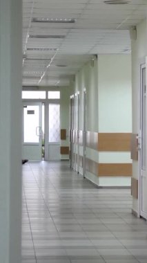 Hastalar olmadan uzun ve boş bir koridor. Hastanedeki plastik kapılar, yeşil duvarlar.
