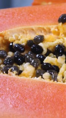 Yarım olgun papaya meyvesi ve tohum. Tatlı, taze hamurlu güzel kokulu tropikal meyve. Çiğ vejetaryen diyeti için ideal. Besin değeri yüksek ve lezzetli. Sağlıklı atıştırmalıklar için mükemmel. Yemeklerdeki tropikal lezzeti arttırır