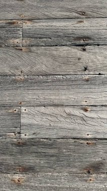 Döşeme tahtasının yatay dokusu ya da döşeme seti, sokak için döşeme. Açık gri panolar, farklı yönlerde hava lekeleri ve çatlaklar. Tahta sert, kahverengi, paslı çivilerle..