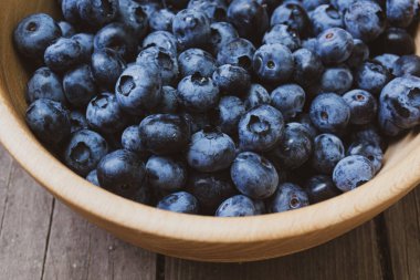 Derin bir ahşap tabakta bir sürü taze yabanmersini..