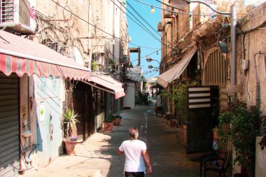Sıcak bir sahil kasabasının eski bir sokağı. Güneş tarafından ısıtılan beyaz taş ve yerel kültürün elementlerinden oluşan dar otantik bir cadde..