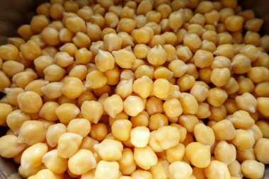 Paslanmaz çelik bir kapta suya batırılmış çiğ nohut yakın çekim, pişirme veya filizlenme için hazırlanıyor.