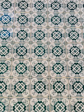 Karmaşık yeşil ve beyaz simetrik dizaynlı geleneksel Portekiz azulejo fayanslarının yakın çekimi.