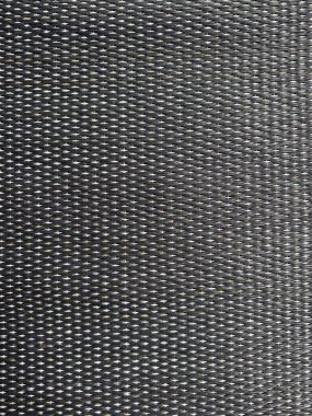 Tekrarlayan desenli koyu renkli sentetik kumaşın detaylı bir yakın çekimi, dokuyu ve karmaşık dokuma detaylarını gösteriyor..