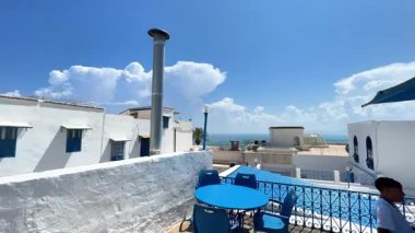 Akdeniz 'de, teras manzaralı, parlak bir gökyüzü altında, mavi aksanlı, bembeyaz binalar..