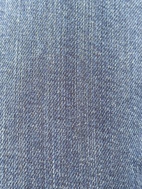 Dar dokumasını ve imzalı çapraz iplik desenini gösteren çok detaylı bir mavi kot kumaşı. Bu doku modada ikoniktir. Anında kot ve iş kıyafetlerinin temeli olarak tanınır..