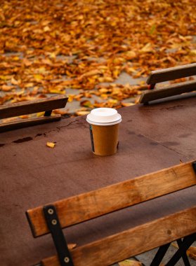 Sonbahar caddesinde, sarı yapraklar ve aromatik kahvenin arka planında sessiz bir sonbahar kafesi. Yüksek kalite fotoğraf